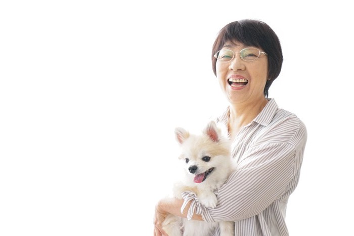 笑顔で犬を抱く女性