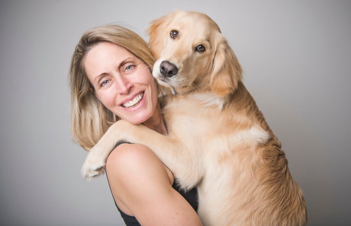 女性に抱っこされる大型犬