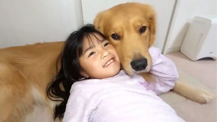 顔を寄せ合う子供と犬