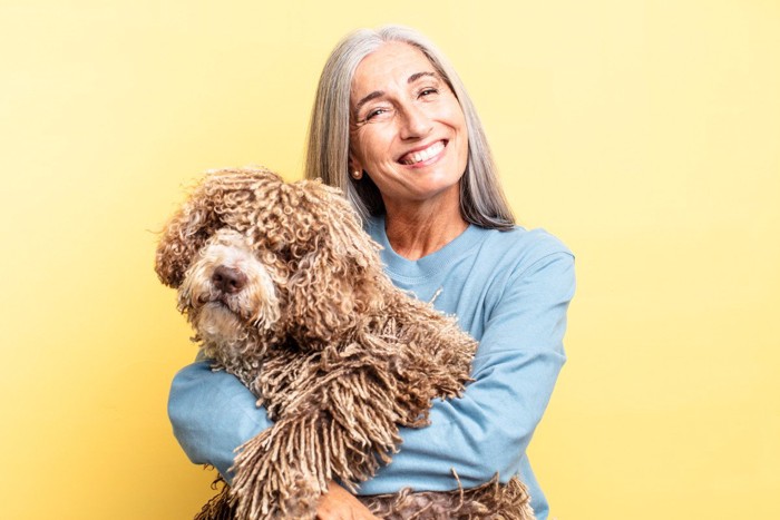 笑顔のシニア世代の女性と犬