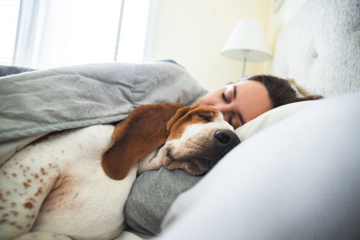 一緒に眠る女性と犬