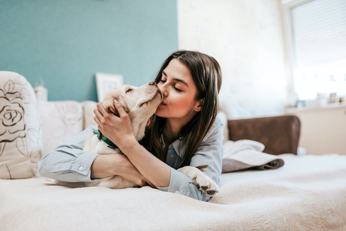 犬の口元にキスをする女性