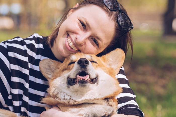 笑顔の犬に顔を寄せる女性