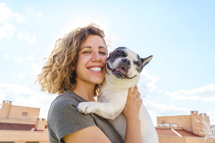 女性と抱き抱えられている犬