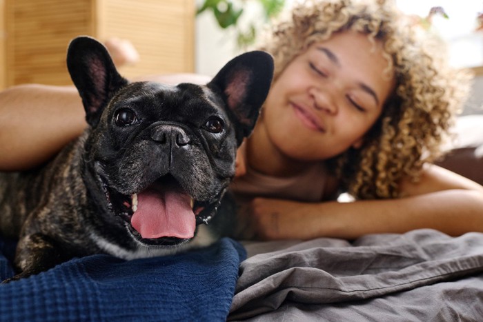 ベッドの上の女性と犬