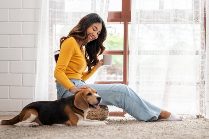 女性の隣に座る犬