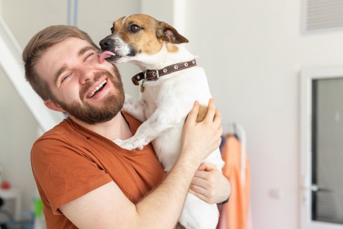 男性の顔を舐める犬